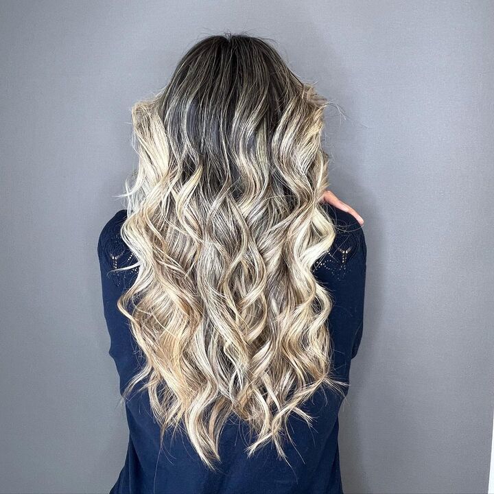 Melena rubia con mechas luminosas y ondas naturales, peinado profesional