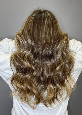 Cabello castaño con ondas definidas y reflejos dorados